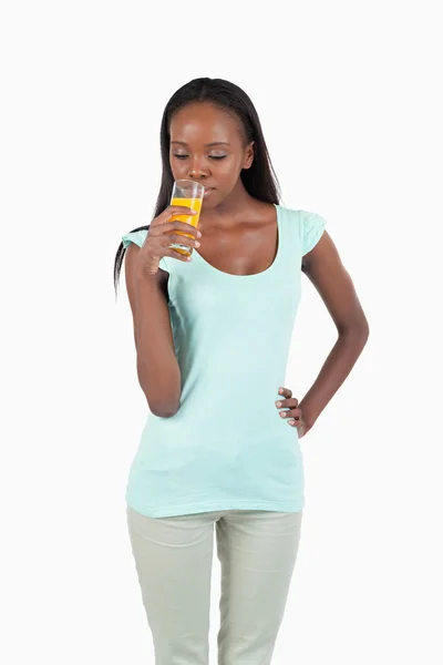 Sorridente giovane donna godendo di un sorso di succo d'arancia — Foto Stock