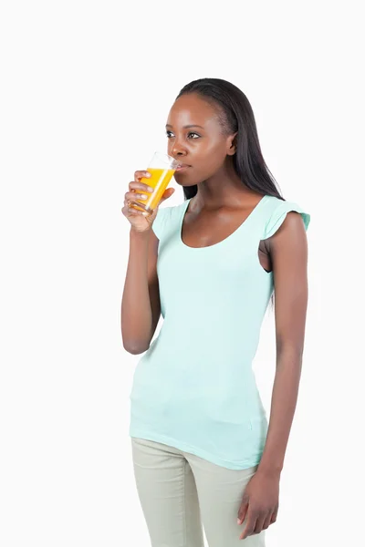 Genç bir kadın portakal suyu içiyor. — Stok fotoğraf
