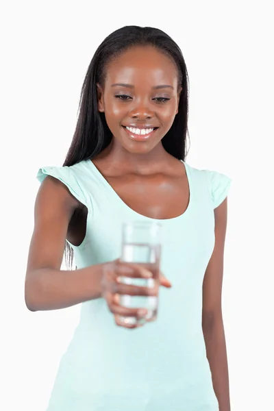 Glada leende kvinna som tittar på glas vatten i handen — Stockfoto