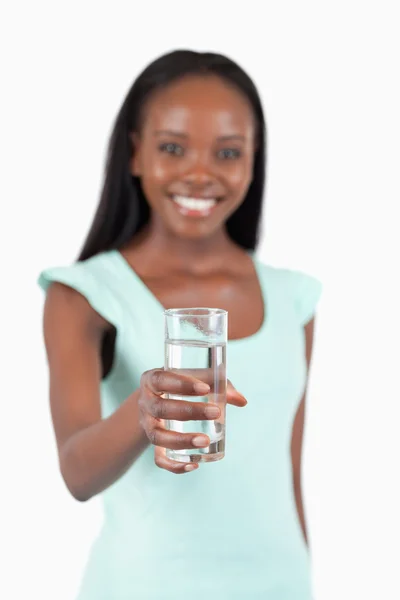 Verfrissende glas water aangeboden door jonge vrouw — Stockfoto