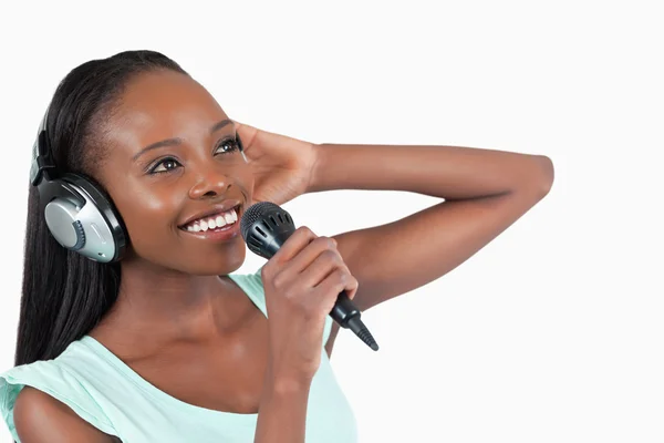 Lächelnde Frau mit Kopfhörern beim Singen — Stockfoto