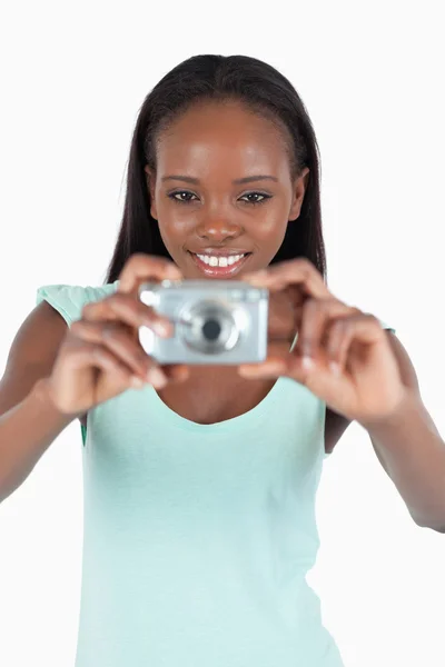 Улыбающаяся молодая женщина, использующая свою цифровую камеру — стоковое фото