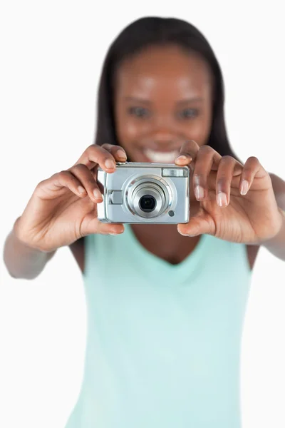 Kamera, jota käytetään hymyilevän nuoren naisen valokuvien ottamiseen — kuvapankkivalokuva