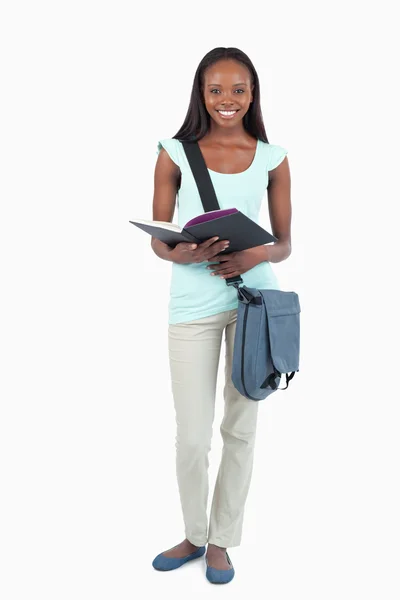 Улыбающаяся юная студентка со своей книгой — стоковое фото