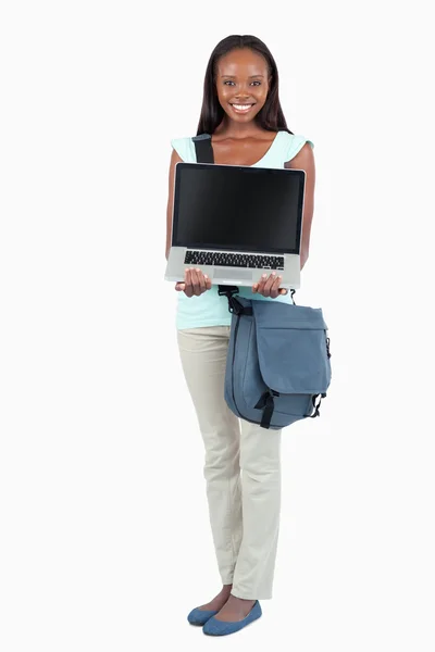 Lachende jonge student toont haar laptop — Stockfoto