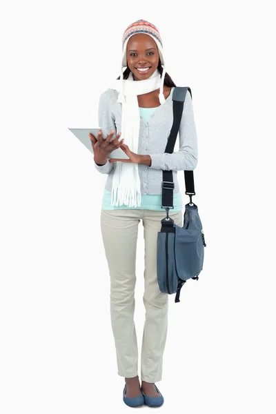 Lächelnde junge Studentin mit Schal, Mütze und Touchpad — Stockfoto