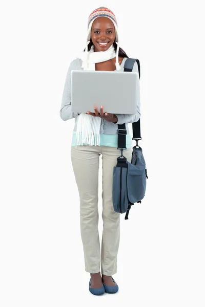 Smiling female student in winter clothing and laptop — Stock Photo, Image
