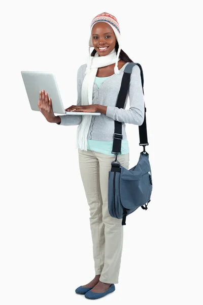 Side view of female student in winter clothing and laptop — Stock Photo, Image