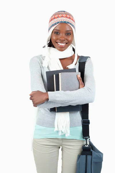 Uśmiechający się młody student w zimowe ubrania z jej książek — Zdjęcie stockowe