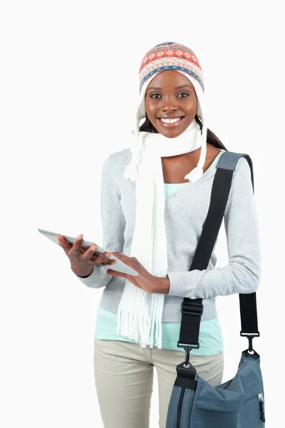 Улыбающаяся юная студентка в зимней одежде со своим планшетом — стоковое фото