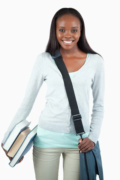 Jovem estudante sorridente com livros e bolsa — Fotografia de Stock