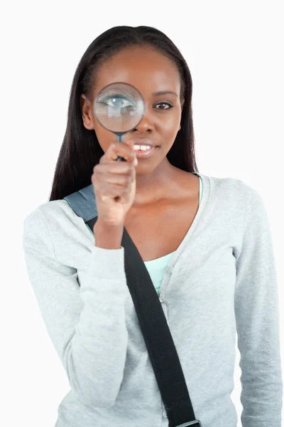 Smiling young woman with magnifier — Stock Photo, Image