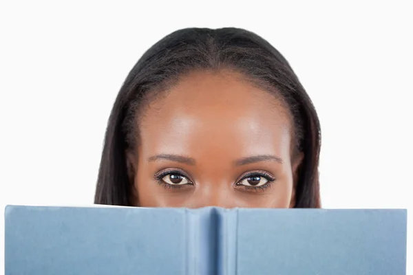 Junge Frau hinter ihrem Buch — Stockfoto