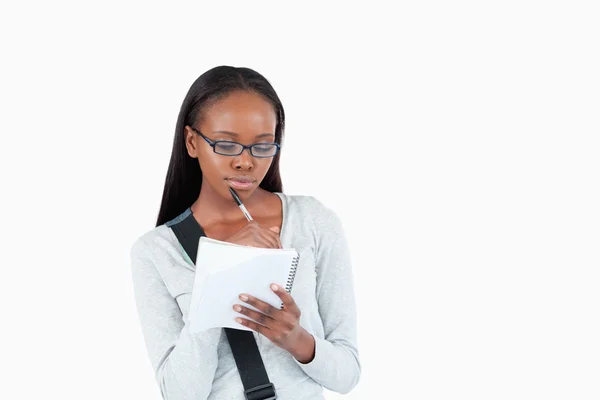 Młoda kobieta z okulary czytanie jej notatki — Zdjęcie stockowe