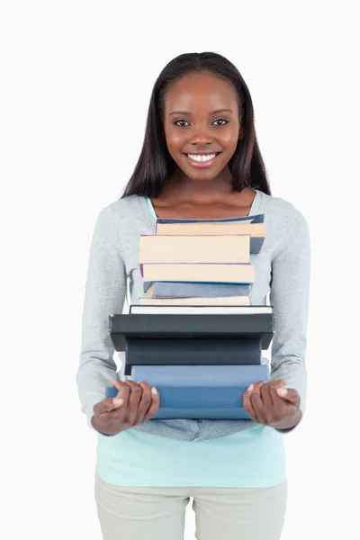 Usměvavá mladá žena s hromadou knih — Stock fotografie
