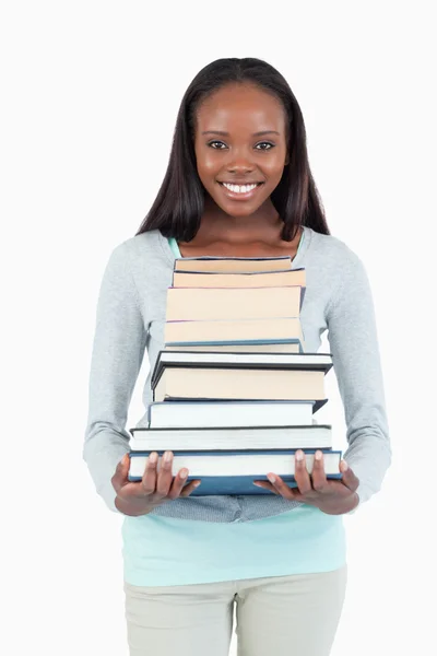 Mujer joven sonriente con pila de libros — Foto de Stock