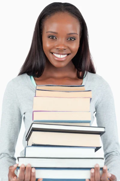 Glada leende kvinna med hög av böcker — Stockfoto