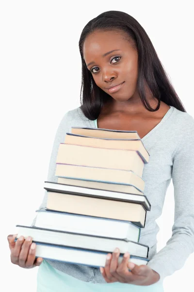 Sad smiling woman with pile of books — Stock Photo, Image