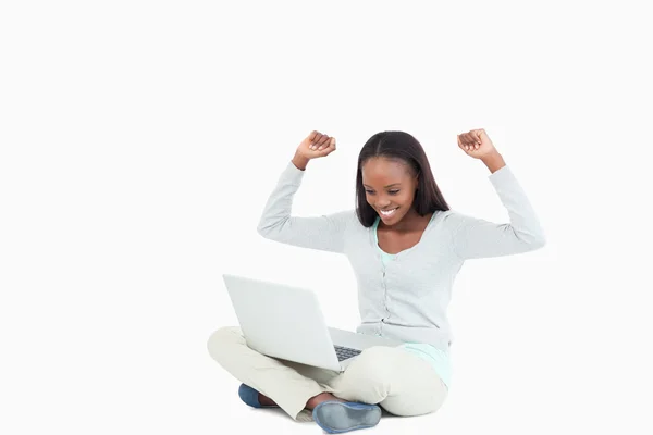 Jeune femme célébrant devant son ordinateur portable — Photo