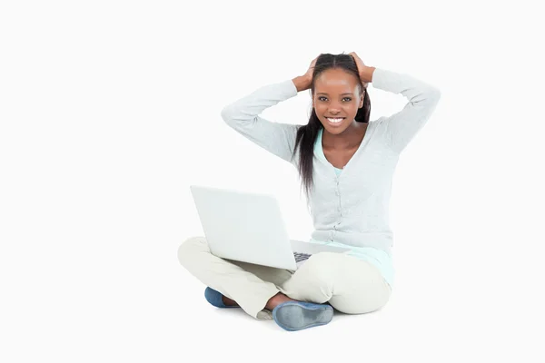 Ung kvinna arg över hennes bärbara dator sitter på golvet — Stockfoto