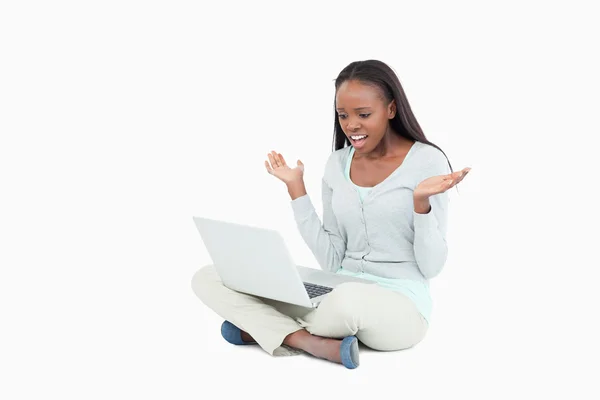 Νεαρή γυναίκα στον αρνητικό λόγο έκπληκτος από το laptop — Φωτογραφία Αρχείου
