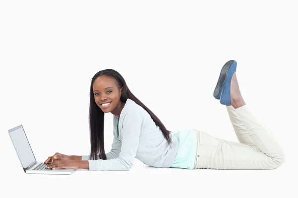 Sidovy av kvinna på golvet med sin laptop — Stockfoto