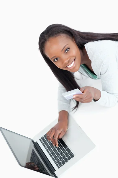 Smiling woman entering credit card information — Stock Photo, Image
