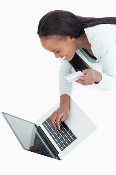 Leende kvinna att skriva i hennes kreditkortsinformation — Stockfoto