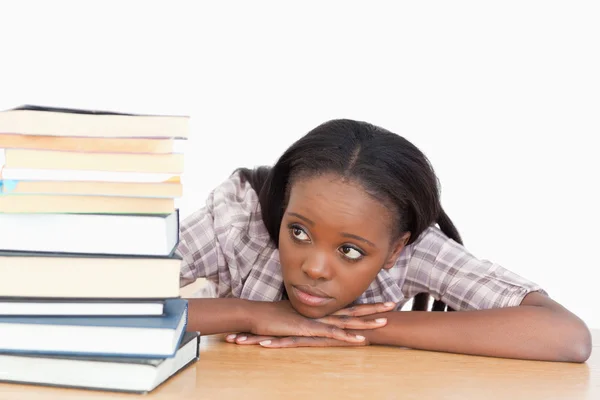 Student looking at a stack of books — Stock Photo, Image