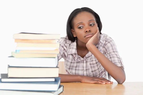 Bored student looking at a stack of books — Stock Photo, Image