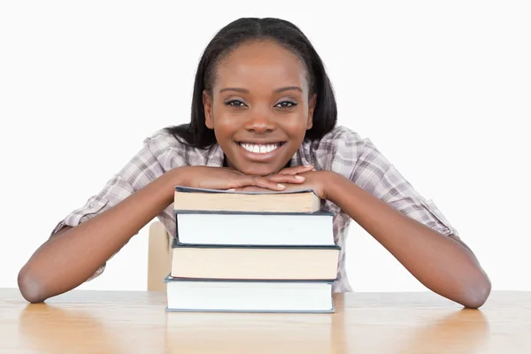 Студентка с подбородком на стопке книги — стоковое фото