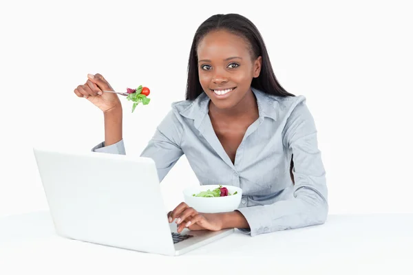 Geschäftsfrau arbeitet mit einem Notizbuch, während sie einen Salat isst — Stockfoto