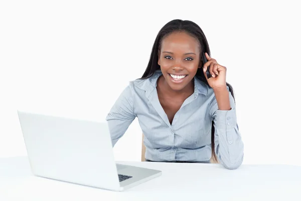 Bir dizüstü bilgisayar kullanırken telefonla iş kadını — Stok fotoğraf