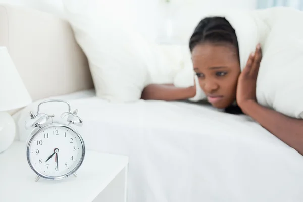 Woman being awakened by her alarm clock — Stock Photo, Image