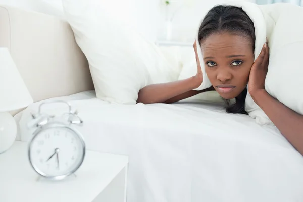 Ung kvinna att bli väckt av hennes väckarklocka — Stockfoto