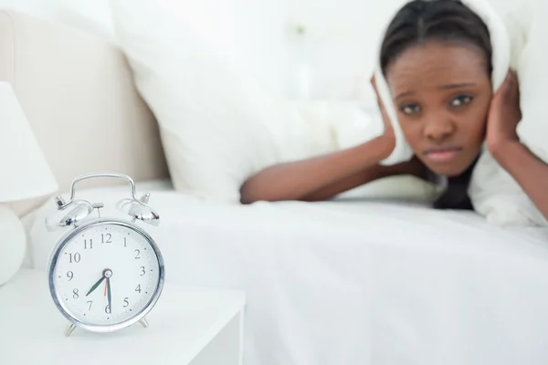 Cute woman being awakened by her alarm clock — Stock Photo, Image