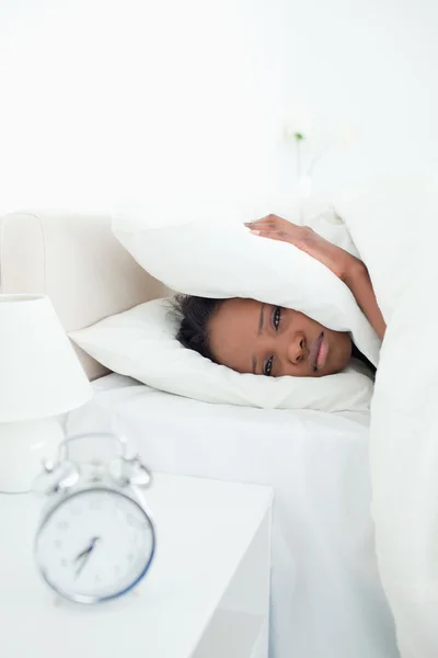 Ritratto di una donna triste che si copre le orecchie mentre la sveglia — Foto Stock