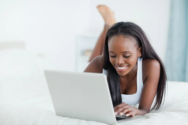 Woman lying on her belly using a laptop — Stock Photo, Image