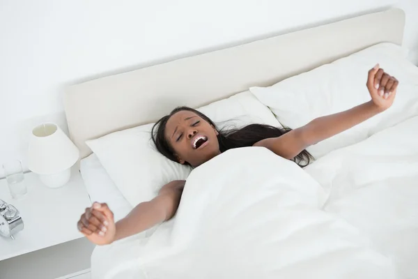 Esneme ve kollarını uyanma sırasında germe kadın — Stok fotoğraf