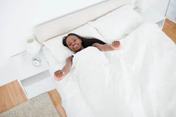 Above view of a woman stretching her arms while waking up — Stock Photo, Image