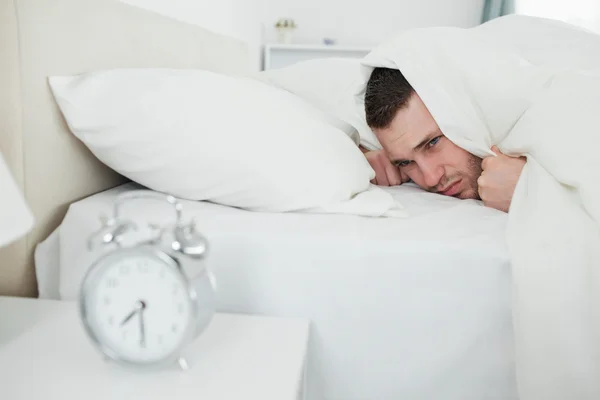 Homem irritado sendo despertado por um despertador — Fotografia de Stock
