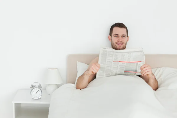 Gülümseyen adam bir gazete okuyor — Stok fotoğraf