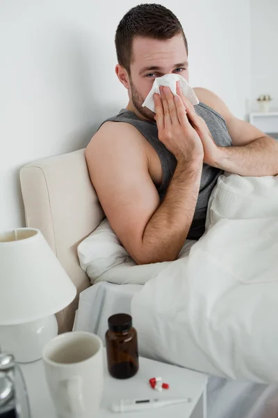 Portrait of a young man blowing his nose — Stock Photo, Image