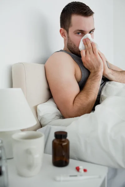 Retrato de un hombre enfermo sonándose la nariz — Foto de Stock