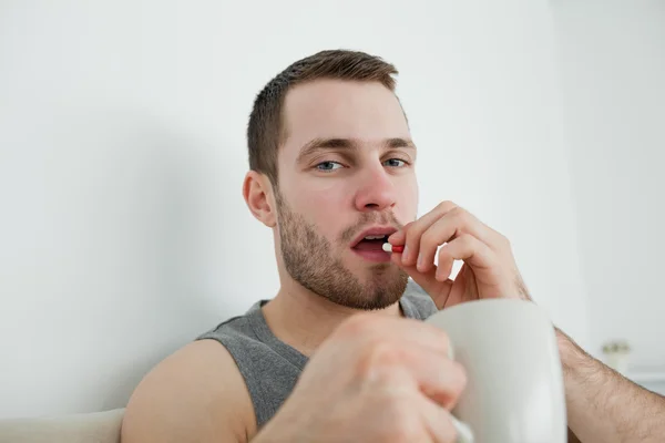 Hombre joven tomando una píldora — Foto de Stock