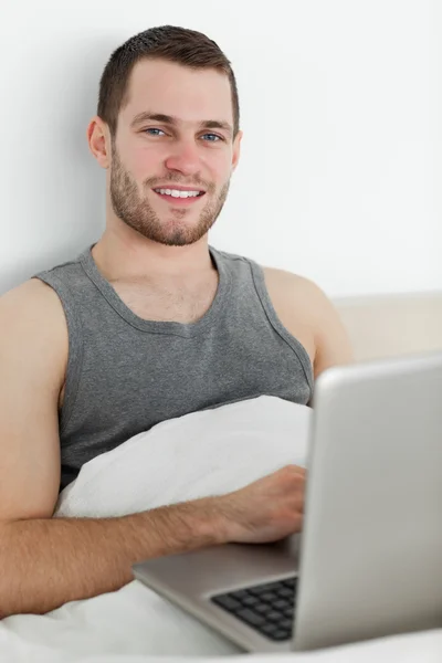 Bir dizüstü bilgisayar kullanarak genç bir adam portresi — Stok fotoğraf