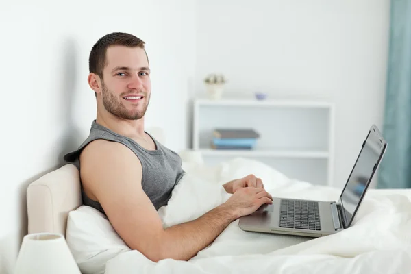 Mutlu bir adam bir dizüstü bilgisayar kullanarak — Stok fotoğraf