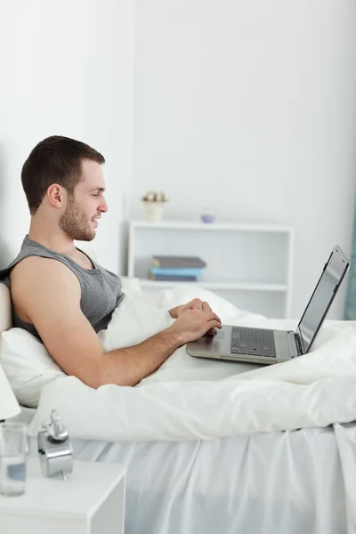 Portrait of a happy man using a laptop — Stock Photo, Image