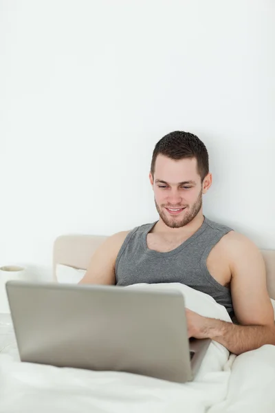 Portret van een jonge man met een laptop — Stockfoto