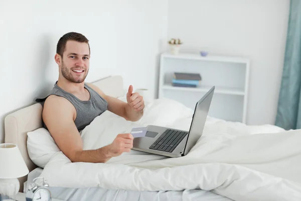 Щасливий чоловік купує онлайн з великим пальцем вгору — стокове фото